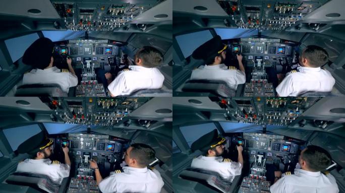 两名飞行员在飞行模拟器中操纵飞机。