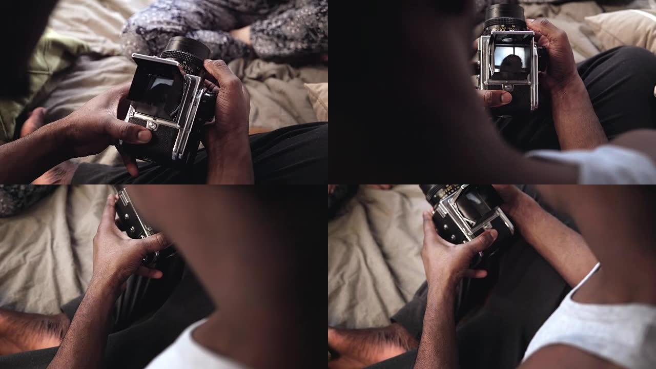 男子在床上的旧移动胶片摄影机上给女人拍照。录像机中女性的观点