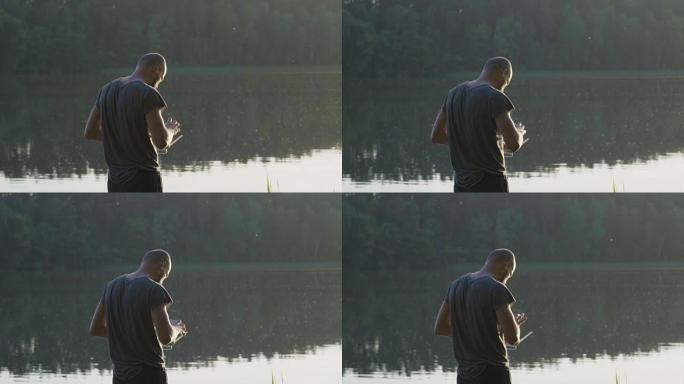 一个年轻人在湖边用无人机工作