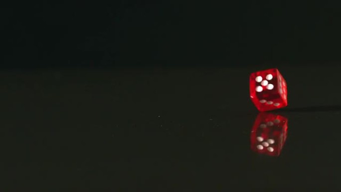 黑色背景上旋转的红色骰子
