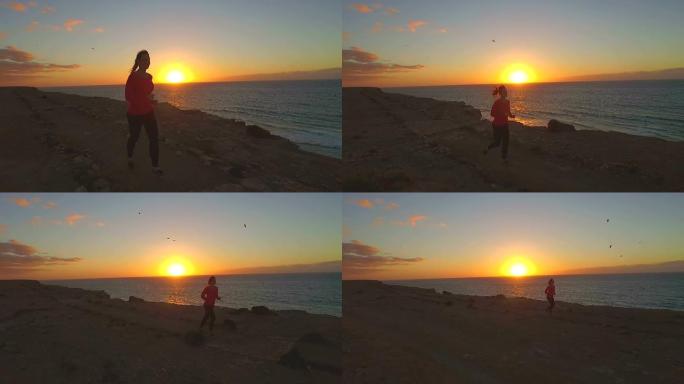慢动作: 日落时女性在悬崖边缘慢跑