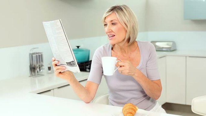 金发女人读报纸喝咖啡