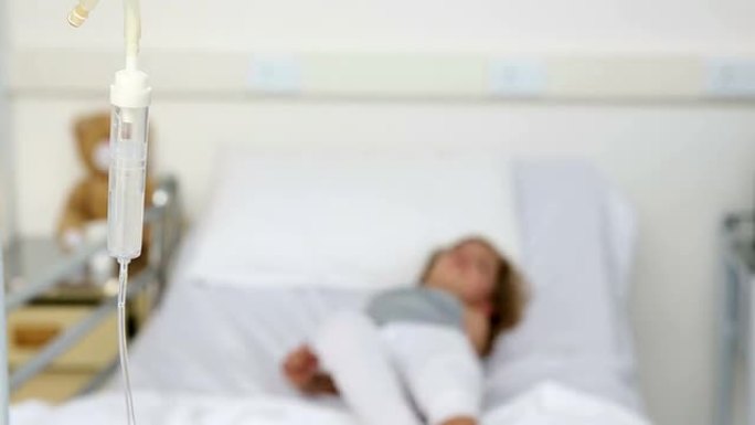 小女孩躺在医院的病床上，静脉滴注