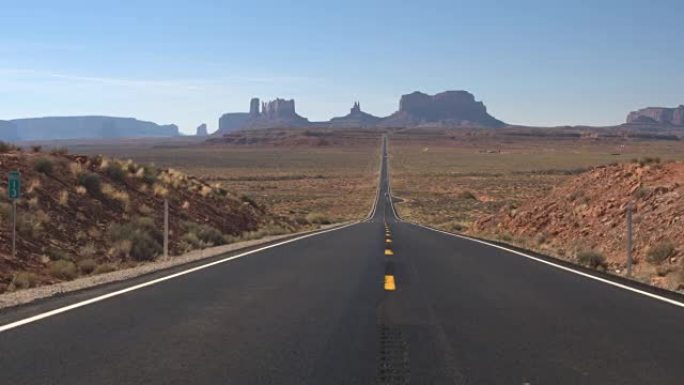 低角度视角直路通向美国阳光明媚的犹他州标志性纪念碑谷