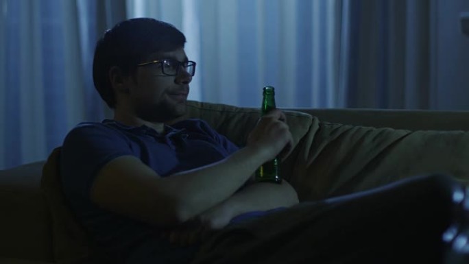 男人在看电视，晚上喝啤酒2