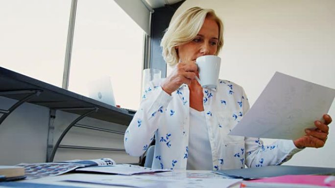 女主管在办公室工作时喝咖啡