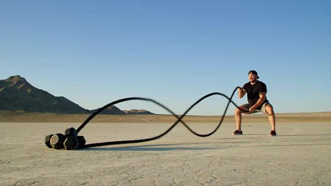 运动男子在沙漠外进行极端的战斗绳索锻炼