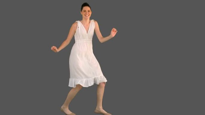 穿着白色连衣裙跳舞的优雅年轻女子