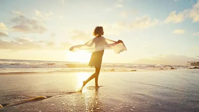 美丽的年轻女子在沙滩上慢动作行走，柔和温暖的复古日落色调