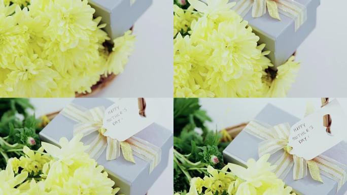 礼品盒和柳条篮中的一束黄色鲜花，带有母亲节快乐标签