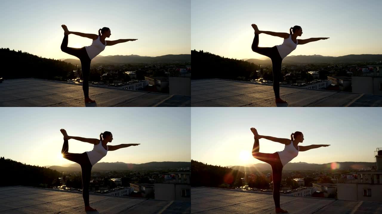 特写: 日出时在摩天大楼顶上做舞蹈瑜伽的女孩