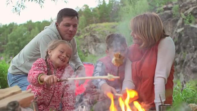 家庭在篝火上烤面包