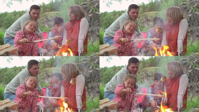 家庭在篝火上烤面包