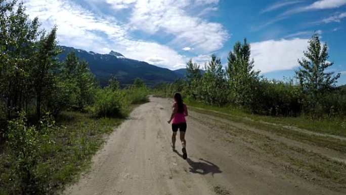 健康女性慢跑通过4k路的后视图