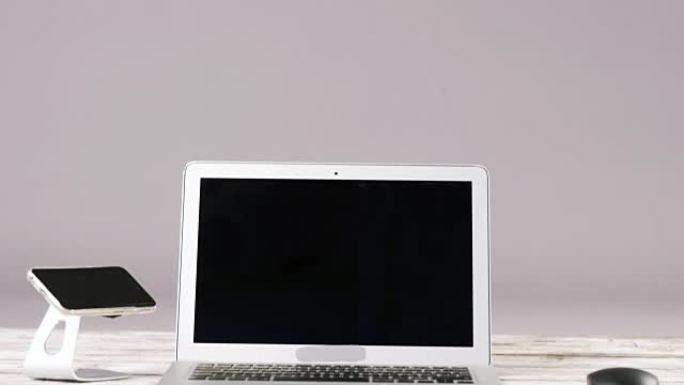笔记本电脑、带支架和电脑鼠标的智能手机