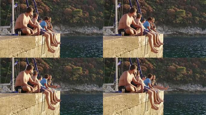 男性朋友放松，坐在海洋上的岩壁上，实时