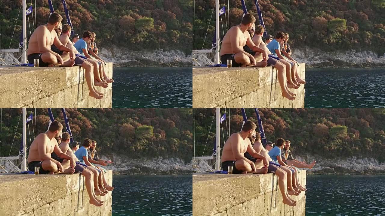 男性朋友放松，坐在海洋上的岩壁上，实时
