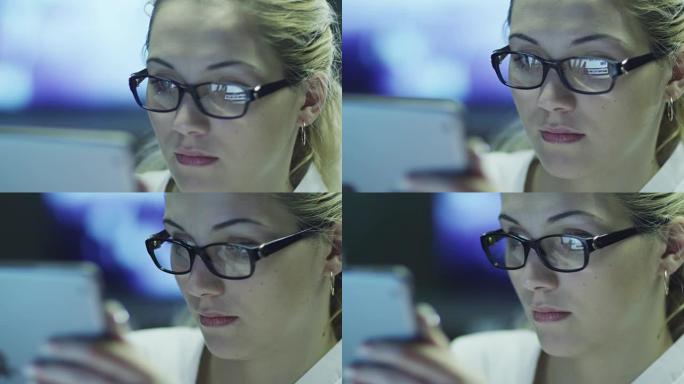 女人正在使用平板电脑，并在眼镜中反射屏幕