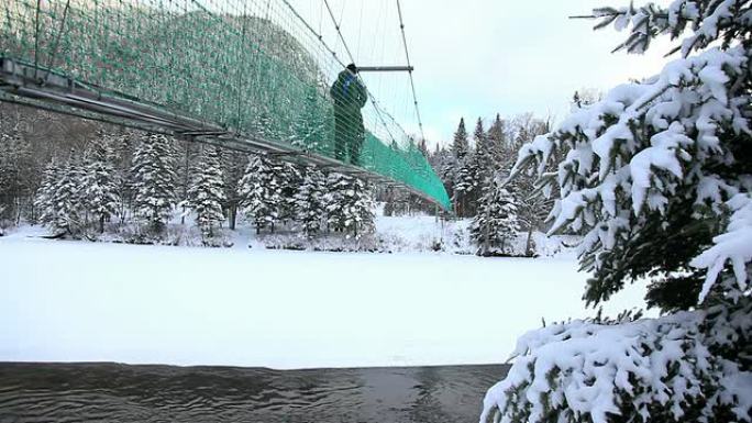 男子在冬季跨过悬索桥