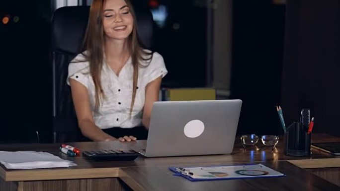一位女商人在笔记本电脑上摘下眼镜。