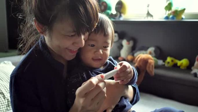 亚洲母亲和儿子发现怀孕测试