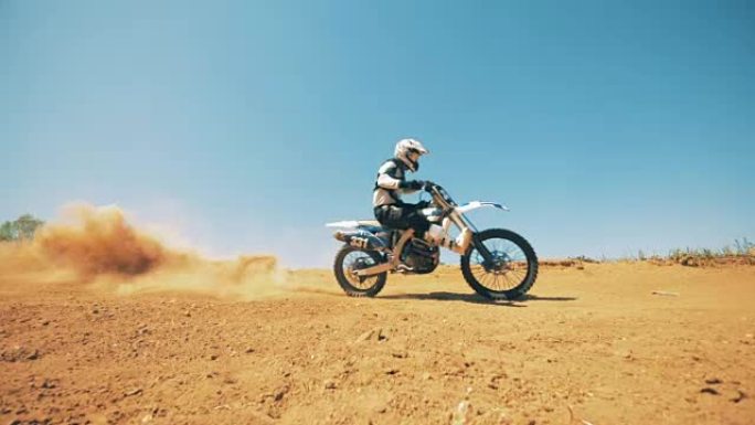 一个骑摩托车的人在沙尘中慢动作地骑着自行车