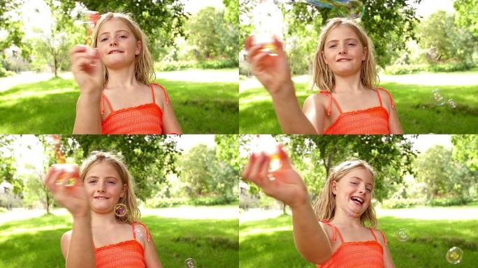 女孩用慢动作的泡泡棒制作泡泡