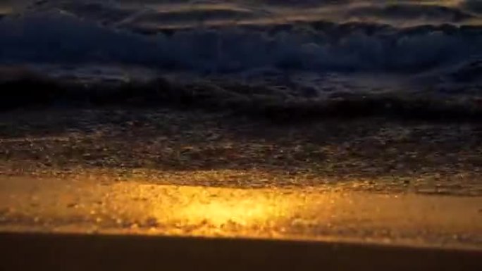 金色的海浪反射日落。日落灯光下的沙滩。4K, UHD