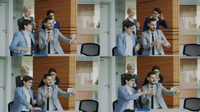 快乐的商业团队在智能手机相机上自拍，并在现代办公室开会时合影留念