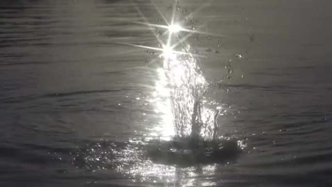 慢动作: 石头扔进水里，太阳闪闪发光