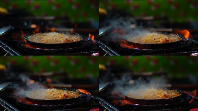 特写烹饪垫的慢动作镜头平底锅里的泰式虾炒米粉