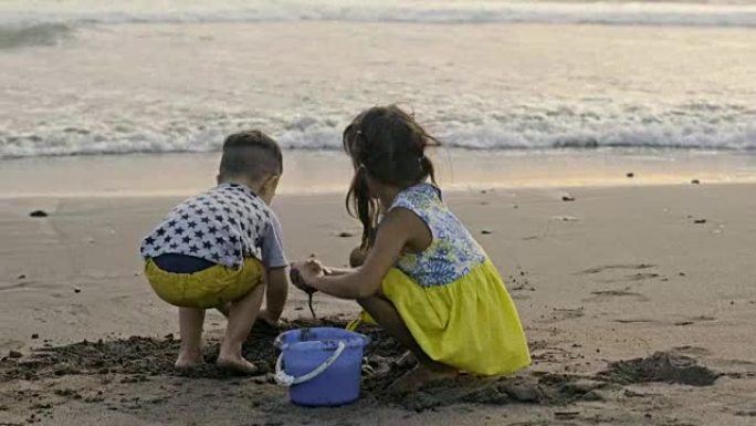 可爱的孩子建造沙堡并逃离海洋
