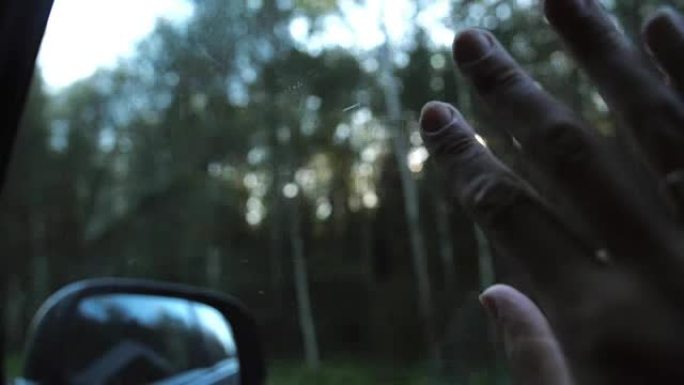 阳光透过手指和树木。在旅途中，用手把戒指放在车窗上。手指手掌。特写。慢mo