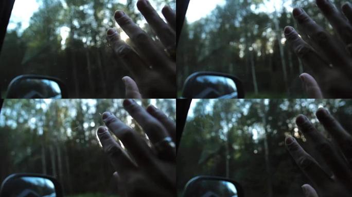 阳光透过手指和树木。在旅途中，用手把戒指放在车窗上。手指手掌。特写。慢mo