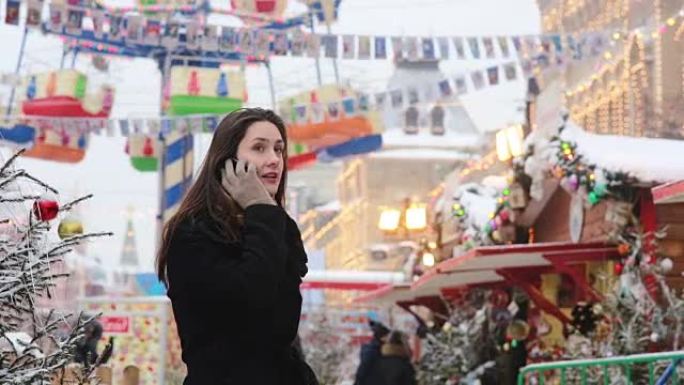 在俄罗斯莫斯科红场的圣诞市场上，冬天站在电话里聊天的女人