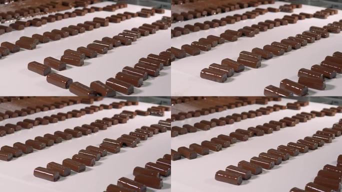 巧克力糖果在工厂的传送带上慢慢走。