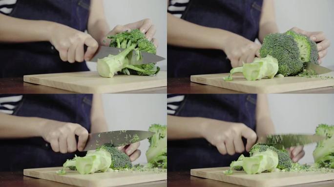 首席女士制作沙拉健康食品并在砧板上切碎西兰花的特写镜头。