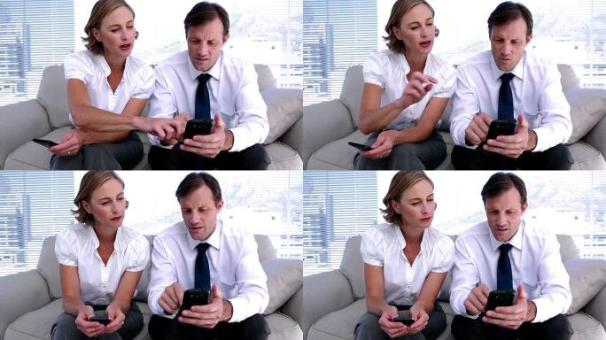 女商人向同事展示如何使用智能手机