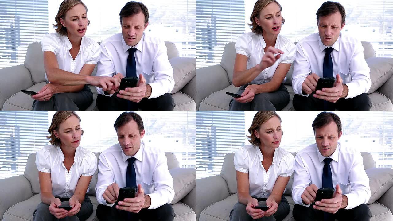 女商人向同事展示如何使用智能手机