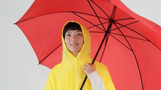 穿着黄色雨衣的女人拿着雨伞4k