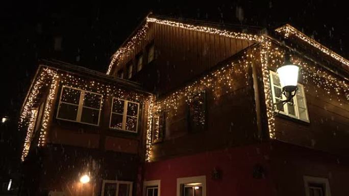 特写: 圣诞节晚上用白色发光灯装饰的木屋