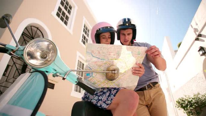 夫妇在旅途中使用地图和他们的踏板车
