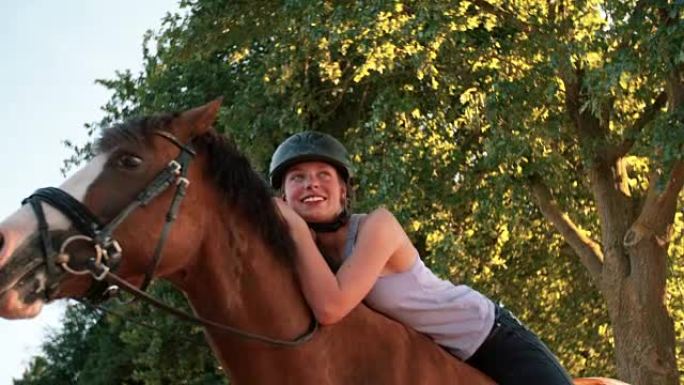 女孩在大自然中骑马时慈爱地靠在马上