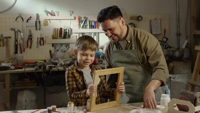 男孩和父亲打磨木制相框