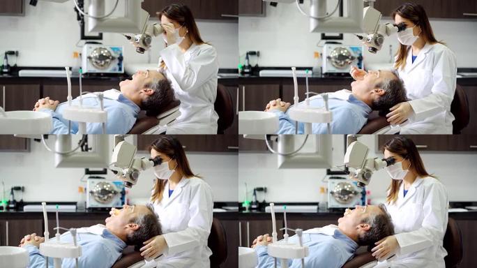 女性牙齿科医生在接受咨询时用显微镜观察患者的牙齿