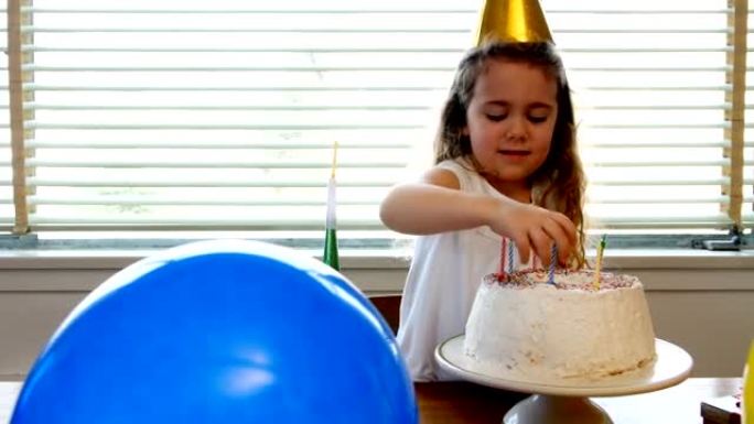 女孩在生日蛋糕上放蜡烛