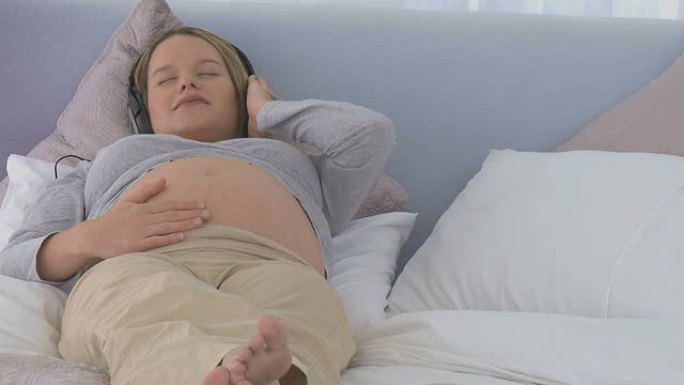 孕妇戴着耳机睡觉