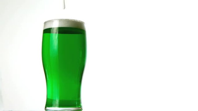 泡沫倒在一品脱绿色啤酒上