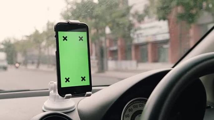 驾驶员在汽车中使用带有绿屏的智能手机，色度键