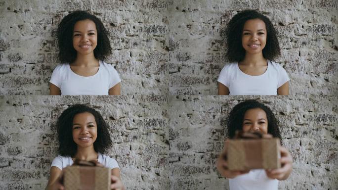 年轻快乐的非洲女孩的肖像赠送礼品盒，微笑着走进相机
